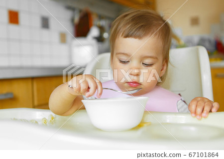 portrait of a child who eats baby food with his spoon. my face is smeared with food 67101864