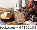 Concept of homemade bread, natural farm products, domestic production. Healthy and tasty organic food. Eggs, butter, bread, milk, flour. Wheat spica as decor. Closeup, wooden background 67102108