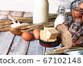 Concept of homemade bread, natural farm products, domestic production. Healthy and tasty organic food. Eggs, butter, bread, milk, flour. Wheat spica as decor. Closeup, wooden background 67102148