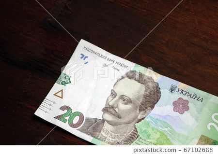 Ukrainian money. Paper twenty hryvnia notes on wooden background. Cash money. Close up shot 67102688