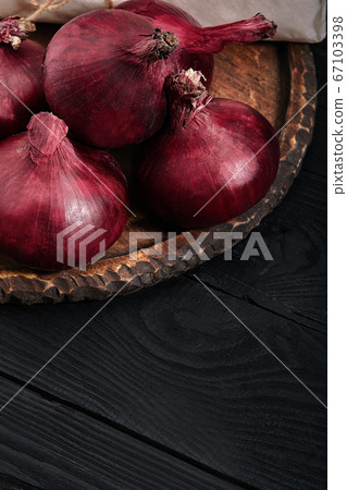 Red organic onion. Farm eco vegetables. Dark background. Red organic onion. Farm eco vegetables. Dark background. 67103398