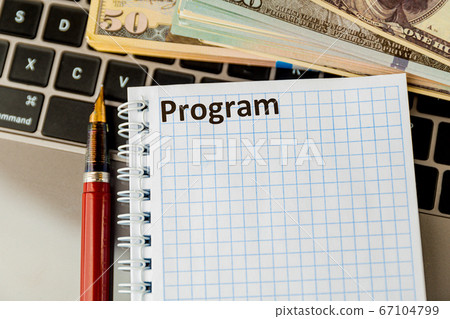 Notepad with word program and money on the laptop. 67104799