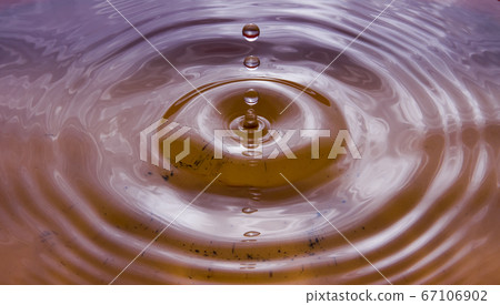 Water droplets falling on the water surface create beautiful ripples  67106902
