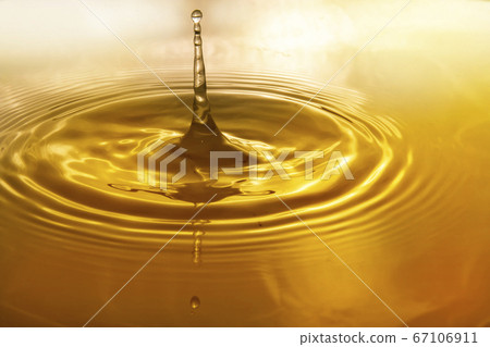 Drops of water on the surface of the water spreading and forming waves 67106911