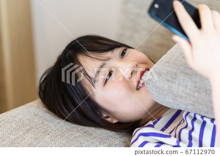 女人在家裡的沙發上放鬆 女人在家裡的沙發上放鬆 67112970
