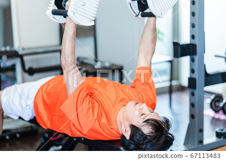 Men using dumbbells in a private gym Men using dumbbells in a private gym 67113483