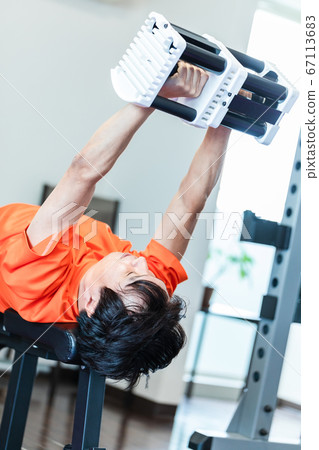 Men using dumbbells in a private gym 67113683