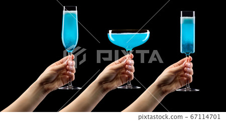 Set of hands holding glass of blue sparkling champagne isolated on black. 67114701