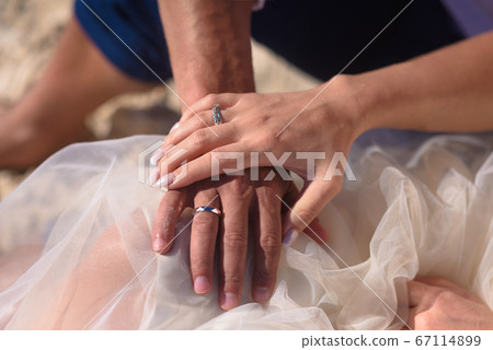 Man and woman newlyweds hold hands close-up. Man and woman newlyweds hold hands close-up. 67114899