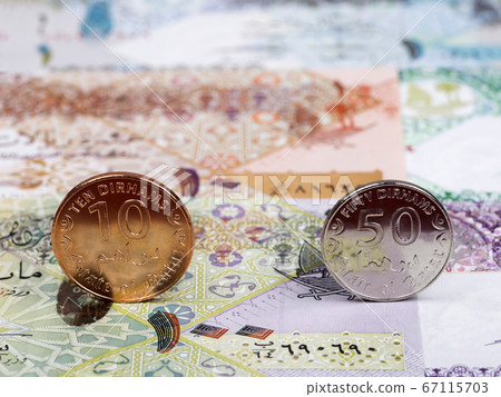 Qatari coins - riyal on the background of money Qatari coins - riyal on the background of money 67115703