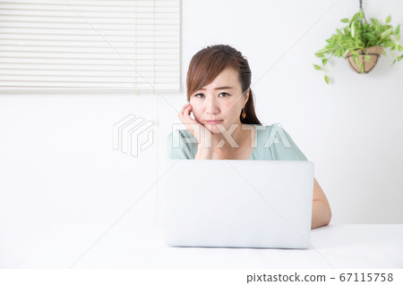 Business woman using a PC (thinking / worrying) 67115758