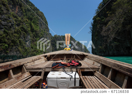 A long tail boat traveling on the sea of Phi Phi Island A long tail boat traveling on the sea of Phi Phi Island 67116838