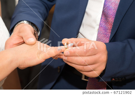 A bride and groom putting on the rings A bride and groom putting on the rings 67121902