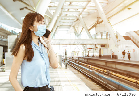 business woman wearing face mask at train station business woman wearing face mask at train station 67122086