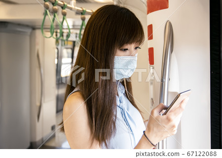 Young Asian woman passenger wearing surgical mask 67122088