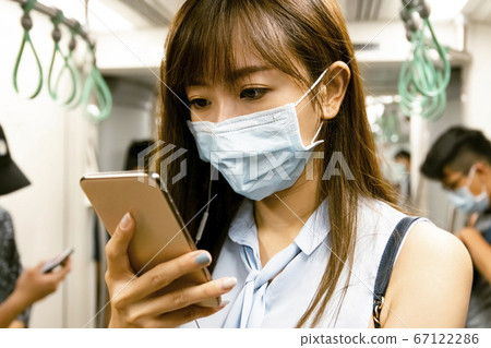 young Asian woman wearing surgical mask in the young Asian woman wearing surgical mask in the 67122286