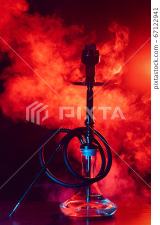 glass hookah shisha with a metal bowl on the table on a black background with smoke 67122941