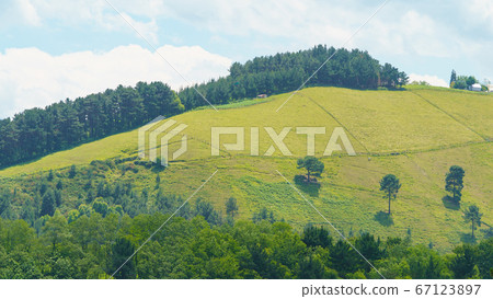 Green landscape in the Basque Country in summer sunny day. Freshness and calmness in the nature. Concepts of the beauty of nature and healthy lifestyles. Ecological trip theme. Green landscape in the Basque Country in summer sunny day. Freshness and calmness in the nature. Concepts of the beauty of nature and healthy lifestyles. Ecological trip theme. 67123897