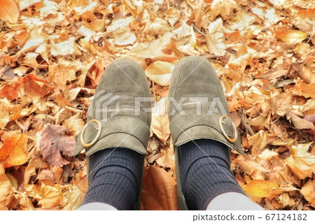 Fallen leaves and feet 67124182