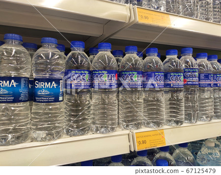 KUALA LUMPUR, MALAYSIA -APRIL 15, 2020: Mineral water is packaged and in plastic bottles and labelled with various brands. Displayed on a shelf inside a supermarket. 67125479
