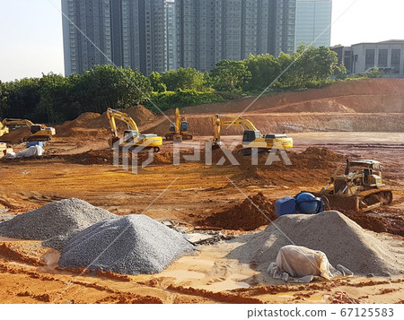 KUALA LUMPUR, MALAYSIA -JULY 17, 2019: Heavy machinery doing the soil backfilling work at the construction site. Works carried out before building construction starts to get the required levels. KUALA LUMPUR, MALAYSIA -JULY 17, 2019: Heavy machinery doing the soil backfilling work at the construction site. Works carried out before building construction starts to get the required levels. 67125583