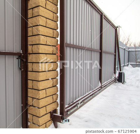 Retractable gate on the fence in winter 67125904