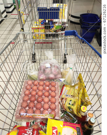 KUALA LUMPUR, MALAYSIA - MARCH 21, 2020: Groceries that have been picked up are placed in the cart before payment is made at the payment counter. Shopping carts make it easy for customers to shop. 67126216