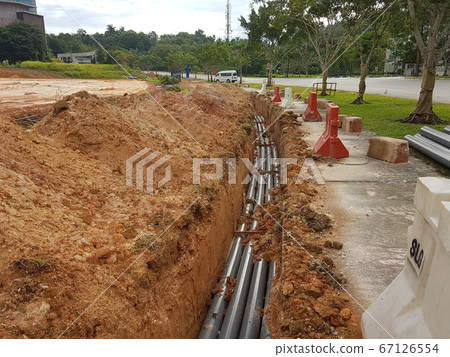 SEREMBAN, MALAYSIA -AUGUST 01, 2019: Underground utility and services pipe laid by workers in the trenches at the construction site. Installation of pipes still ongoing. SEREMBAN, MALAYSIA -AUGUST 01, 2019: Underground utility and services pipe laid by workers in the trenches at the construction site. Installation of pipes still ongoing. 67126554