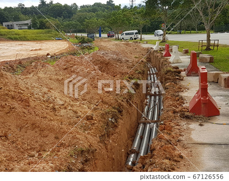 SEREMBAN, MALAYSIA -AUGUST 01, 2019: Underground utility and services pipe laid by workers in the trenches at the construction site. Installation of pipes still ongoing.     67126556