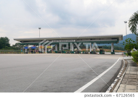 SEREMBAN, MALAYSIA -MAY 26, 2020: Highway toll canopy in Malaysia. Vehicles that use the expressway through a toll plaza and make payments each time they enter and exit. SEREMBAN, MALAYSIA -MAY 26, 2020: Highway toll canopy in Malaysia. Vehicles that use the expressway through a toll plaza and make payments each time they enter and exit. 67126565
