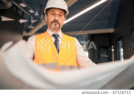 Architect man working with blueprint in the office Architect man working with blueprint in the office 67126713