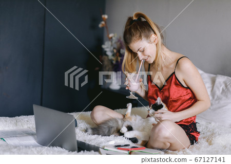 Young student drinking milkshake and playing with cat 67127141