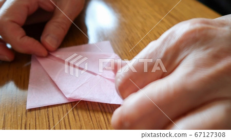 Woman folding origami close up Woman folding origami close up 67127308