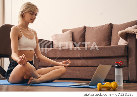 Sporty young lady practicing yoga at home Sporty young lady practicing yoga at home 67128153