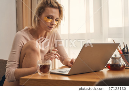 Serious teleworker looking at the computer screen 67128180