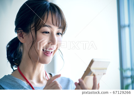 Smiling businesswoman calculating (casual) 67129266
