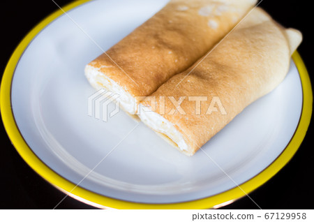 Rolled nalesnik stuffed with cheese. Nalesnik is Polish pancake. Rolled nalesnik stuffed with cheese. Nalesnik is Polish pancake. 67129958