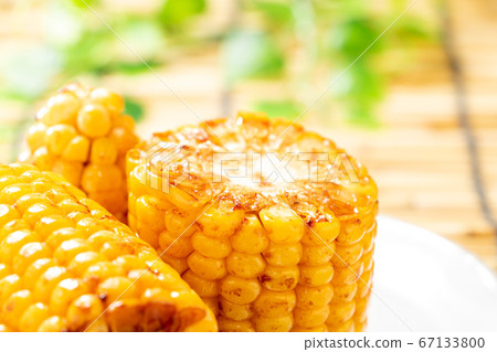 烤玉米(烤黃油醬油)。在背景窗簾中的夏天圖像。 烤玉米(烤黃油醬油)。在背景窗簾中的夏天圖像。 67133800