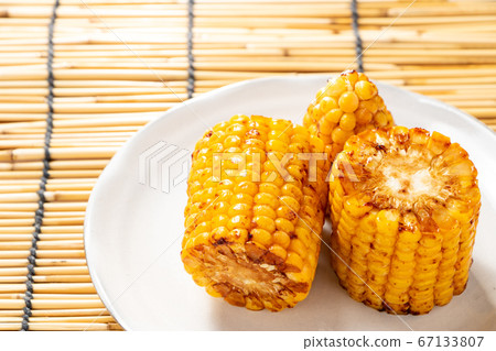 烤玉米(烤黃油醬油)。在背景窗簾中的夏天圖像。 烤玉米(烤黃油醬油)。在背景窗簾中的夏天圖像。 67133807