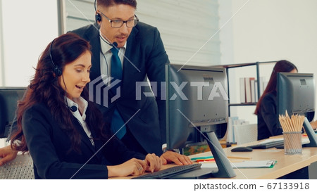 Business people wearing headset working in office Business people wearing headset working in office 67133918