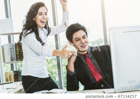 Two happy business people celebrate at office 67134257