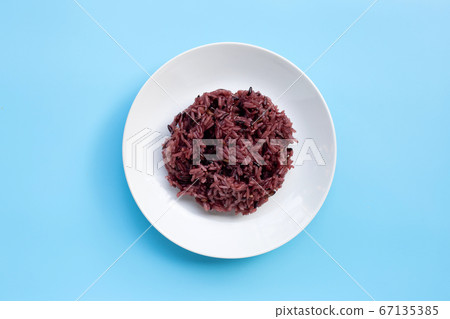 Black sticky rice on white ceramic dish on blue Black sticky rice on white ceramic dish on blue 67135385