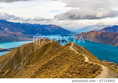 New Zealand hiking people on mountain top Roys Peak enjoying active outdoor lifestyle arms raised cheering happy in New Zealand nature landscape, near Wanaka, Otago, South Island, New Zealand 67139903