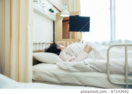 Woman lying in bed at hospital [hospital] 67143692