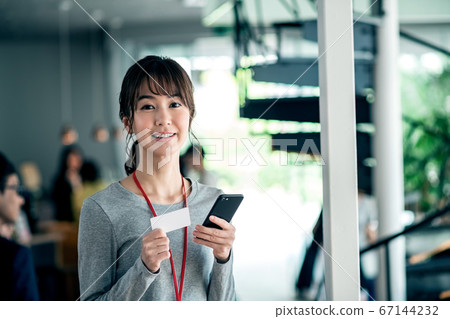 Business woman shopping with a smartphone using a card in the office 67144232