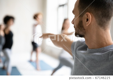 Yoga male trainer giving master class to group of students. 67146225