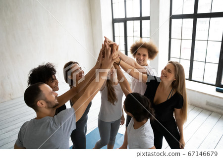Young multiracial people in activewear giving high five after training. Young multiracial people in activewear giving high five after training. 67146679
