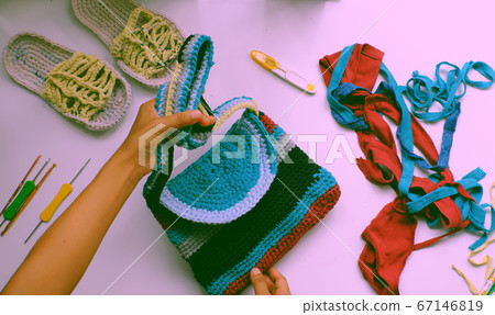 Close up from top view woman hand hold colorful handmade bag from recycle old t shirt Close up from top view woman hand hold colorful handmade bag from recycle old t shirt 67146819