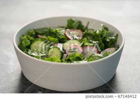Summer fresh salad with radish, cucumber and herbs in white bowl Summer fresh salad with radish, cucumber and herbs in white bowl 67148412