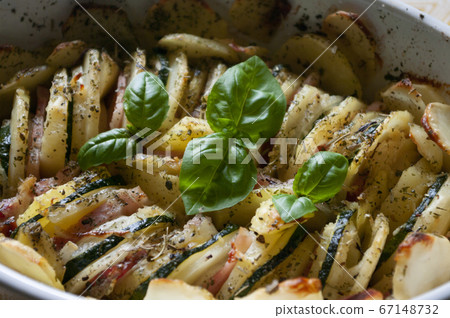 Baked potato gratin bacon and zucchini,freshly served from the oven on a wooden table.Casserole food,vessel. Close up. Baked potato gratin bacon and zucchini,freshly served from the oven on a wooden table.Casserole food,vessel. Close up. 67148732